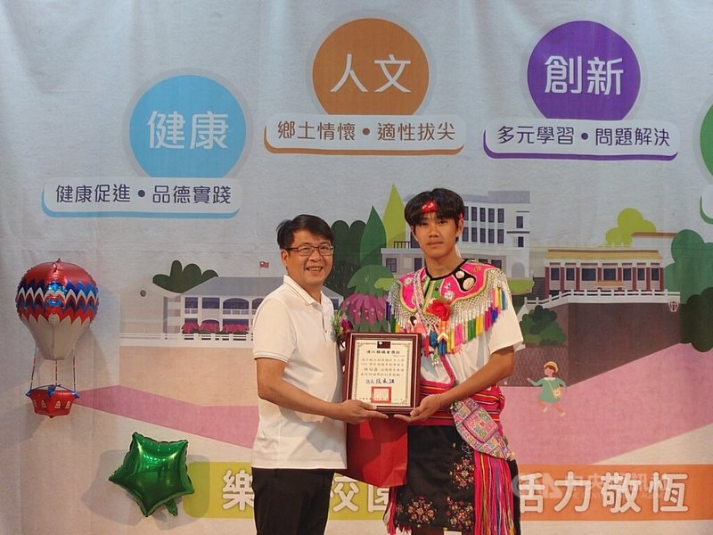 連江縣敬恆國中小11日舉辦畢業典禮,國中部唯一的畢業生楊冠鑫(右),從莒光鄉公所祕書曹恆忠(左)手中,領到優秀畢業生議長獎。中央社記者潘欣彤攝 114年6月13日
