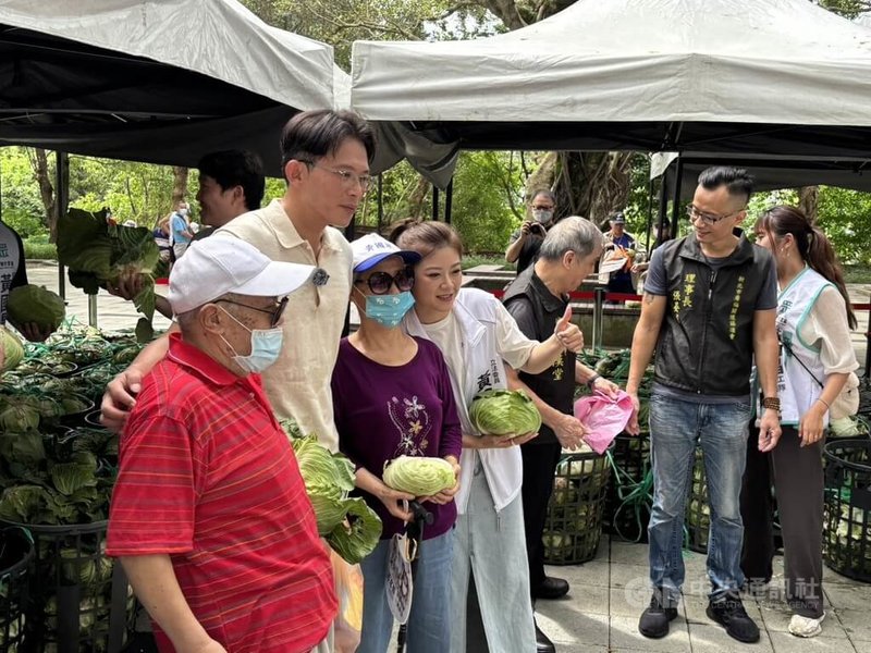 民眾黨主席黃國昌(左2)14日偕新北服務處板橋區主任林子宇(左4)發放高麗菜給在地居民。中央社記者郭建伸攝 114年6月14日