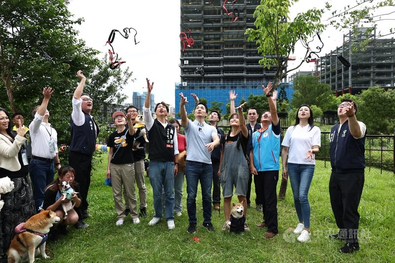 台北市南港區新新公園狗活動區14日下午舉行啟用活動,台北市長蔣萬安(前右5)也到場參與,眾人一同拋出手中牽繩,宣告狗活動區正式啟用。中央社記者翁睿坤攝 114年6月14日