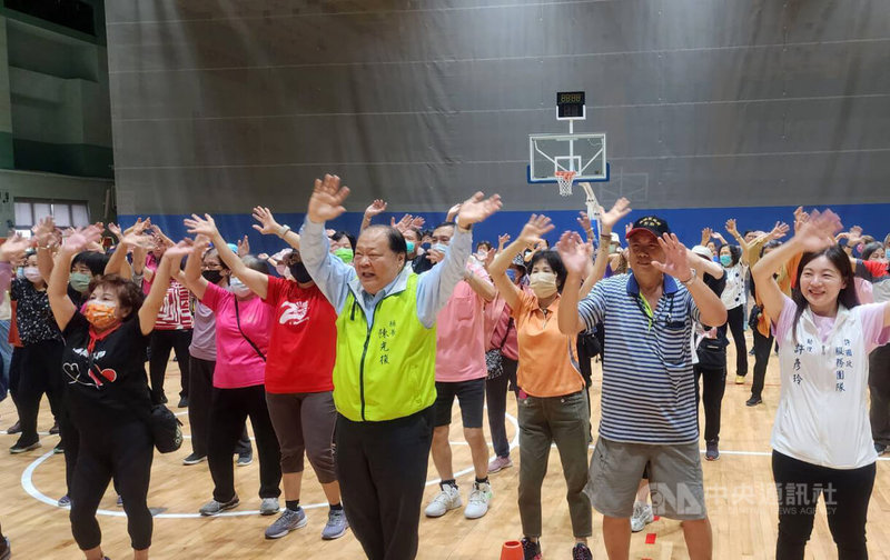澎湖縣健康樂活運動協會14日舉辦「三代同堂運動趣 銀向健康動起來」活動,縣長陳光復(前排左2,黃背心)出席,與民眾一同暖身。中央社 114年6月14日