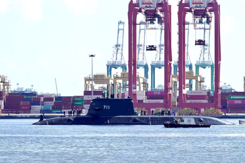 國造潛艦原型艦海鯤艦（中）14日在高雄港內進行浮航，以自主動力在港區進行浮航，可看見海鯤艦甲板上有多名技術人員，帆罩上亦有數人，且帆罩內的光電桅杆亦豎起，舷號711清晰可見，一旁並有小船伴航。中央社記者董俊志攝  114年6月14日