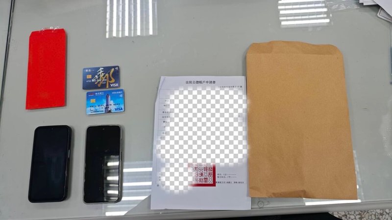 台中市警察局第二分局立人派出所員警日前執行巡邏勤務時,發現1名形跡可疑男子正與婦人交換牛皮紙袋與紅包袋,警方進一步查證後,確認男子假冒檢警人員進行詐騙,當場逮捕這名馬來西亞籍的面交車手,並查扣手機、金融卡及法院公證本票等贓證物。(民眾提供)中央社記者郝雪卿傳真 114年6月15日