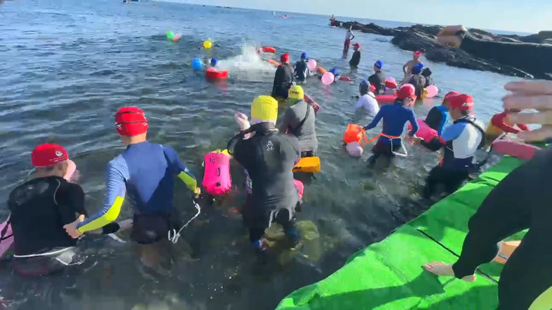 基隆外木山海上長泳活動15日一早在外木山水域熱鬧登場,其中16名身心障礙選手在陪游員帶領下下水。(讀者提供)中央社記者王朝鈺傳真 114年6月15日