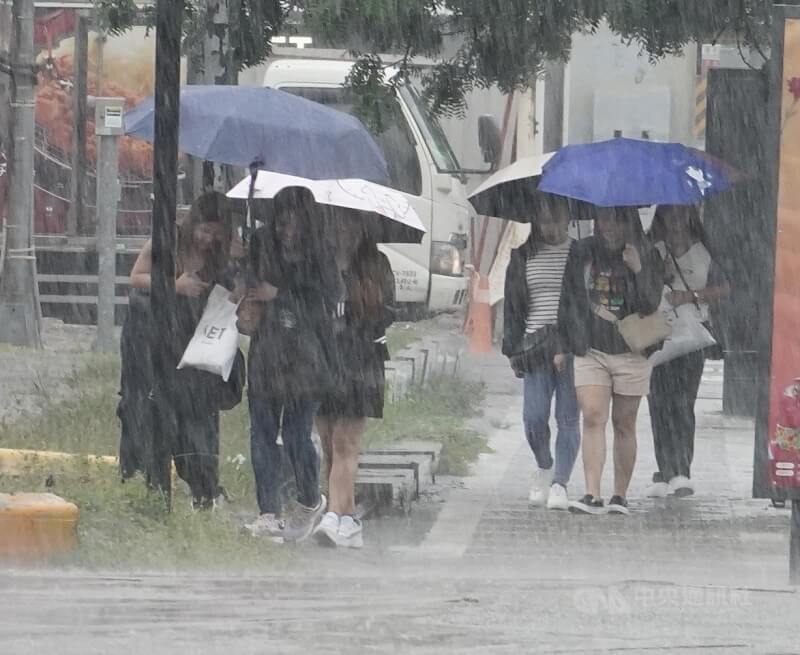 中央氣象署16日更新大雨特報,受西南風影響及對流雲系發展旺盛,易有短延時強降雨,雲林以南地區有局部大雨發生機率。圖為高雄市區午後下起陣雨,路上行人紛紛撐傘。中央社記者董俊志攝 114年6月16日