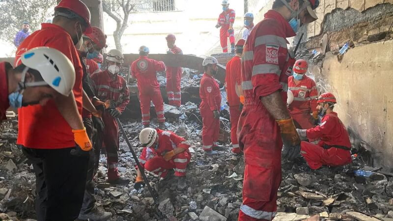 圖為伊朗紅十字會成員在遭以色列襲擊後的建築中找尋傷者。(Iranian Red Crescent Society via路透社)