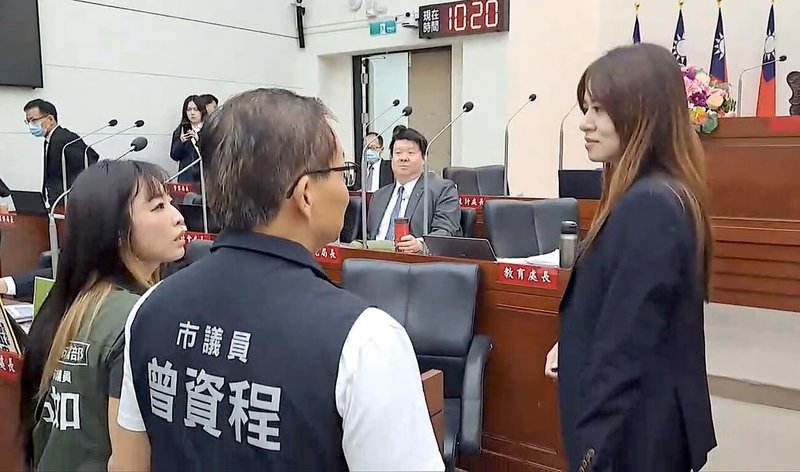 新竹市議會民進黨團17日質詢時,於代理市長邱臣遠座位前擺放「同意罷免」手舉牌,民政處長施淑婷(右)休息時間欲上前收起,遭民進黨議員喝斥,雙方爆發口角。(讀者提供)中央社記者魯鋼駿傳真 114年6月17日