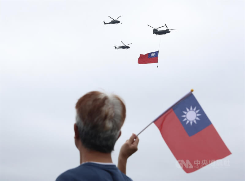 113年國慶大會CH-47SD契努克運兵直升機吊掛巨幅國旗通過北市上空,民眾也揮舞國旗迎接。(中央社檔案照片)
