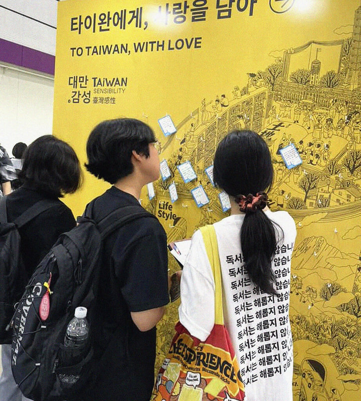2025首爾國際書展18日在韓國首爾江南區COEX展覽中心開幕,台灣首次擔任主題國,共有23名跨領域作者前往參展。圖為韓國讀者在台灣館前留言牆上留下給台灣的祝福。(台北書展基金會提供)中央社記者邱祖胤傳真 114年6月18日