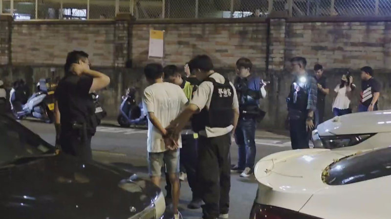 台中警方掌握陳姓男子（左2）因案遭通緝且持有槍械，19日晚間循線埋伏逮人，陳男發現後開車逃逸，最終在警車前後包夾下，成功將人逮捕並查扣槍械。（江和樹提供）中央社記者蘇木春傳真  114年6月19日