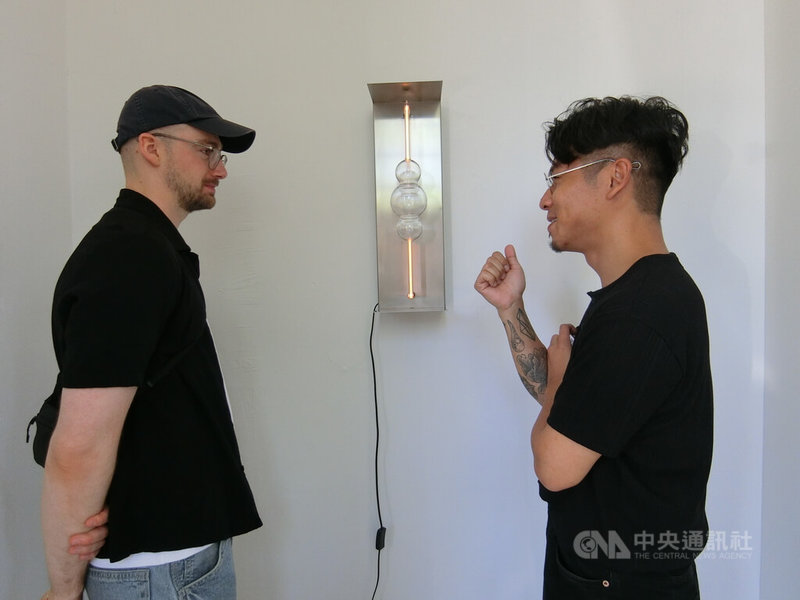 陳彥安(右)的作品The Spheroid讓霓虹透過玻璃球體消散,象徵霓虹燈產業在1960年代的沒落,霓虹的使用讓參觀民眾感到好奇。中央社記者辜泳秝哥本哈根攝 114年6月20日