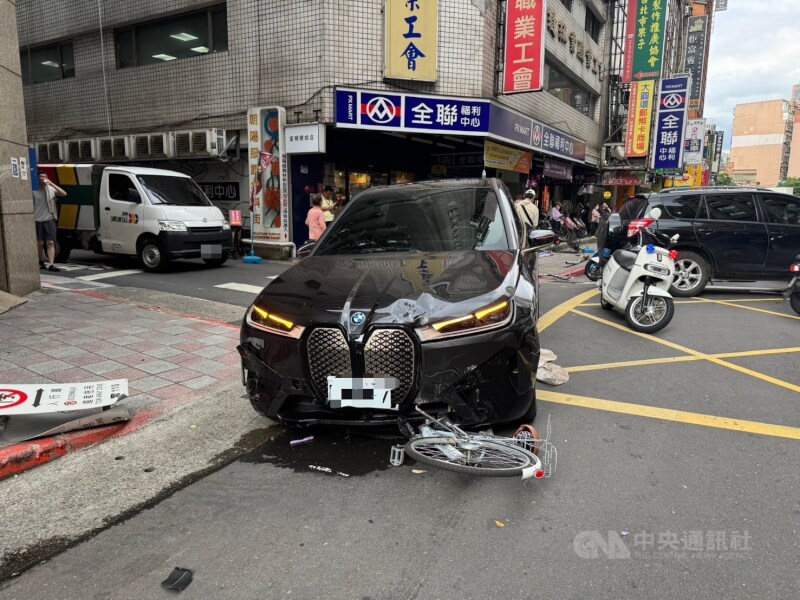 台北市警消20日下午獲報在南京西路167巷附近發生車禍,人員到場發現一輛黑色BMW汽車卡在路口,附近多輛機車及自行車受損,另有1名年約60幾歲婦人受傷,涉肇事駕駛為74歲曾姓男子。(翻攝照片)中央社記者劉建邦傳真 114年6月20日