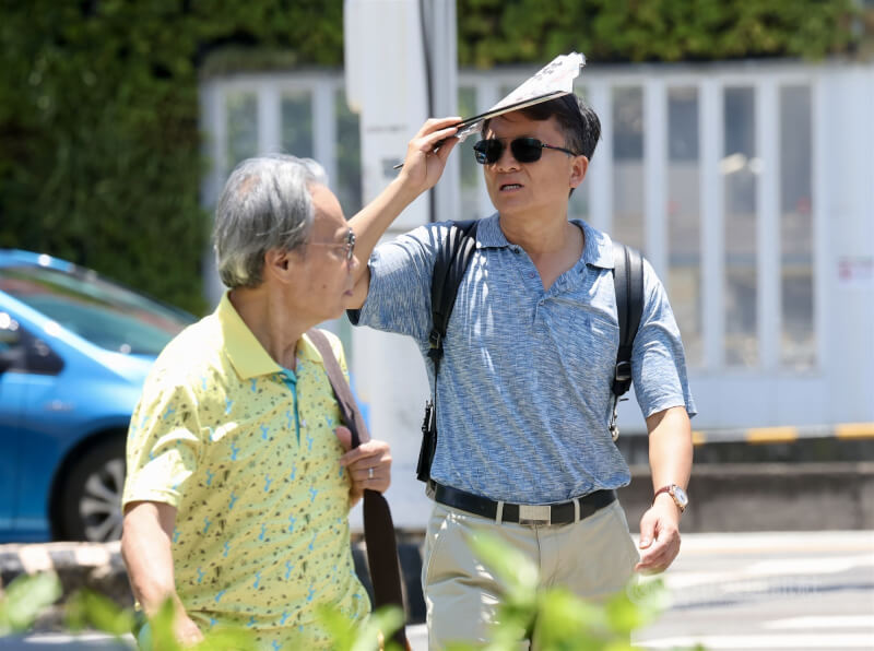 圖為台北市中正區，民眾戴墨鏡、用物品遮擋豔陽。（中央社檔案照片）