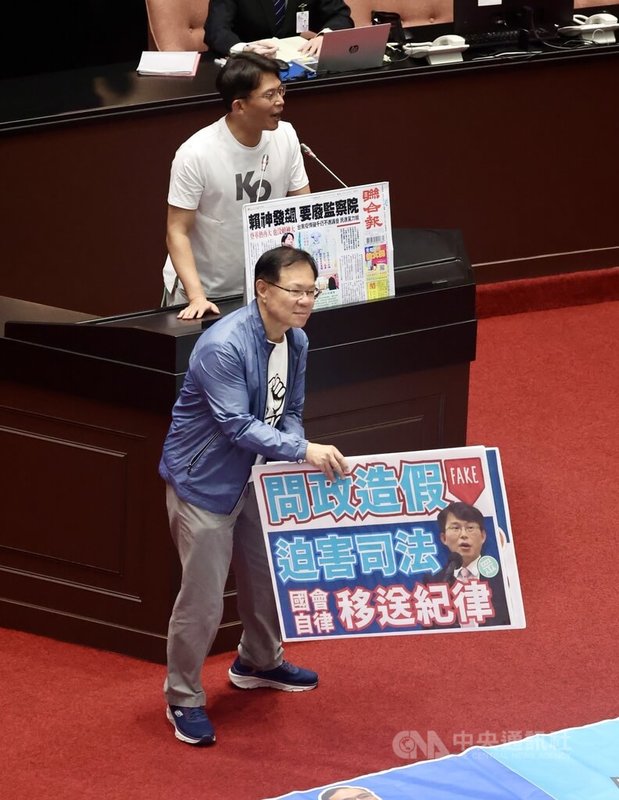 民眾黨立委黃國昌(後)20日在立法院會發言時,倡議修憲廢除監察院,民眾黨立委張啓楷(前)幫忙收拾民進黨要將黃國昌送紀律委員會的標語看板。中央社記者王飛華攝 114年6月20日