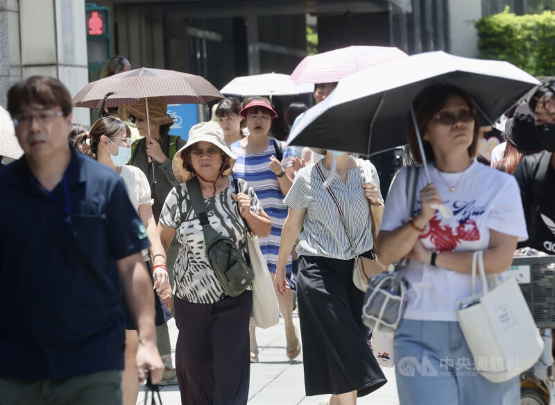 圖為台北市中正區民眾撐傘防曬。(中央社檔案照片)