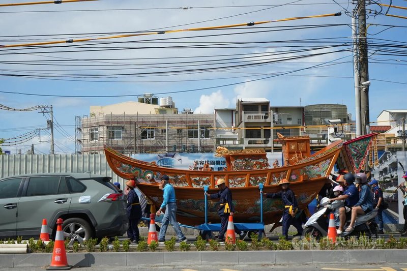 由東港東隆宮打造、象徵溫府千歲神威的典藏王船,由溫府千歲壓陣隨行,東港東隆壇頂頭角轎班全程護送,陸上行舟與信眾及汽機車攜手前行,最終行至王船文化館安座。中央社記者黃郁菁攝 114年6月22日