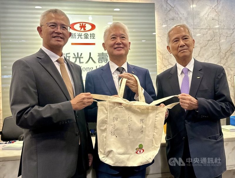 台新金控、新光金控合併基準日為7月24日,6月23日是新光金最後一場股東會。會後新光金董事長魏寶生(中)、新光人壽副董事長洪士琪(左)、新光金董事陳淮舟(右)一同在股東會紀念品上簽名留念。中央社記者張璦攝 114年6月23日