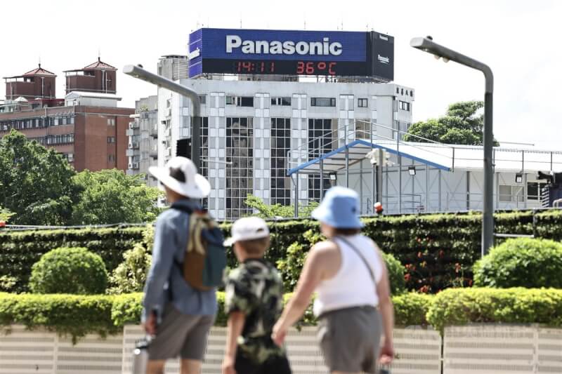台北市信義區街頭民眾戴帽子防曬。(中央社檔案照片)