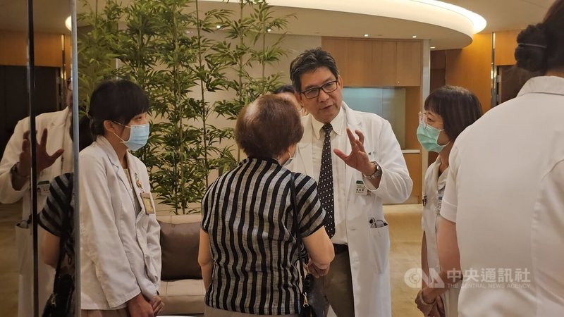 亞東醫院神經醫學部失智中心主任甄瑞興(右3)首例為83歲女性患者(背對者)說明施打的過程。中央社記者王鴻國攝 114年6月23日
