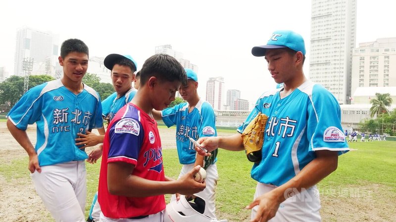 2025年小馬聯盟帕馬級亞太區青棒錦標賽23日在馬尼拉揭幕,台灣隊輕取菲律賓麥杜姆鎮,圖為麥杜姆鎮選手找投手羅于晏(前右)簽名。中央社記者林行健馬尼拉攝 114年6月23日