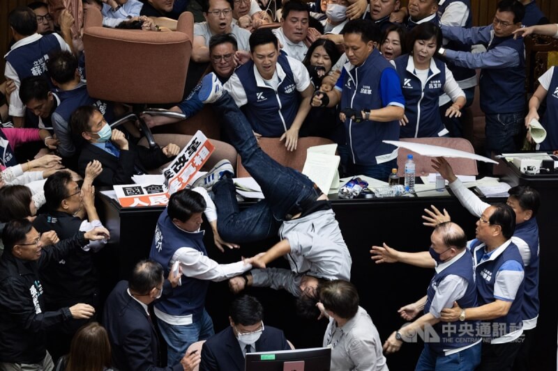 民進黨立委沈伯洋(中摔落者)等人2024年5月在立法院審議國會職權法案時,欲搶占主席台但遭國民黨立委推落,沈伯洋以倒栽蔥方式摔下,隨後被救護車送往醫院就醫。(中央社檔案照片)