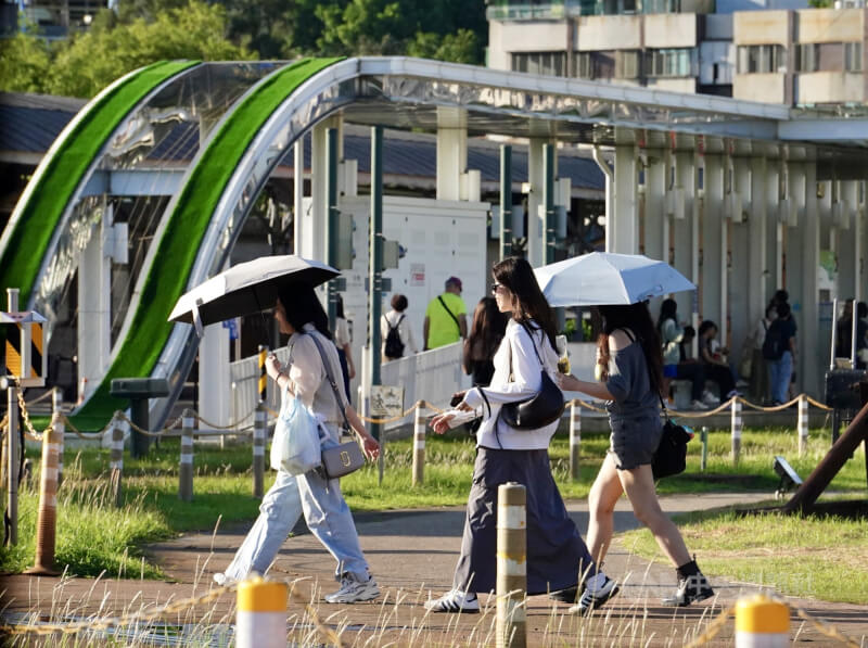 圖為高雄市鼓山區民眾撐傘遮陽。(中央社檔案照片)