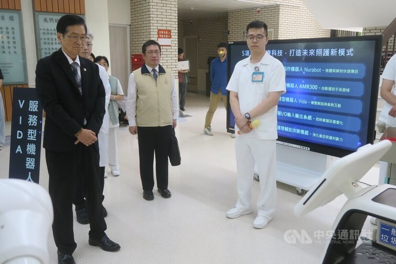 退輔會主委嚴德發(左)24日視導台中榮民總醫院,院方展示多款先進醫療機器人的應用情況。中央社記者吳書緯攝 114年6月26日