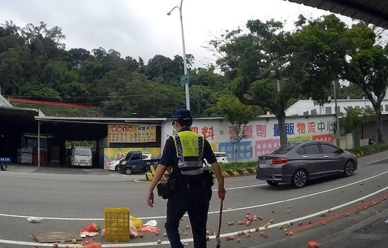 57歲黃姓果農日前載著桃子要到市場販售,在台中市石岡區豐勢路與另輛機車發生碰撞,桃子散落一地,警方與附近居民一同協助清理。(民眾提供)中央社記者趙麗妍傳真 114年6月26日
