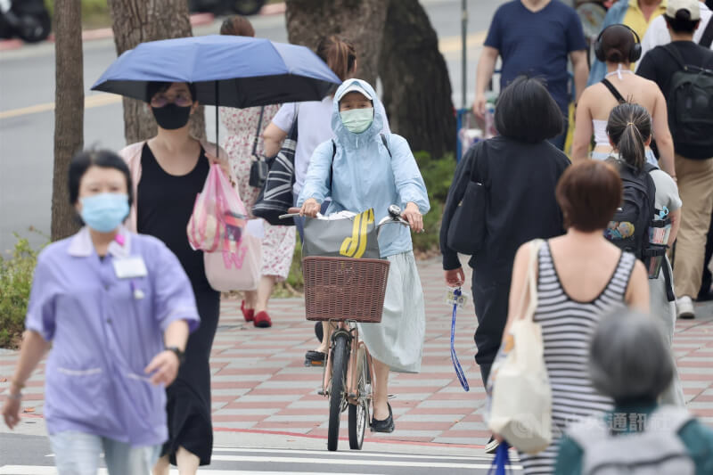 圖為北市中正區街頭民眾全身包緊緊防曬。中央社記者王飛華攝 114年6月18日