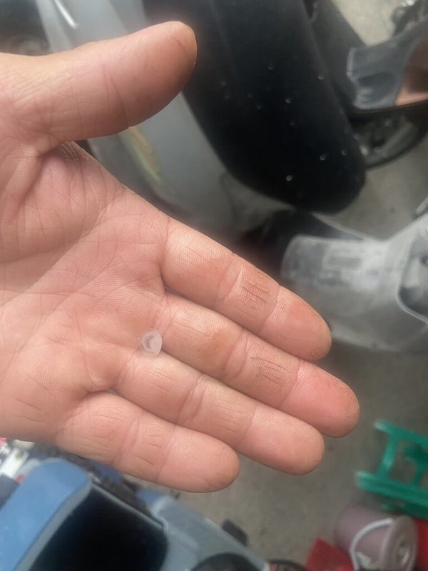屏東縣26日下午烏雲密布且伴隨陣陣雷鳴,屏北地區隨後下起大雨,鹽埔鄉、高樹鄉居民更陸續發現屋外落下冰雹,有人特別跑出屋外撿起冰雹觀察。(宋姓民眾提供)中央社記者李卉婷傳真 114年6月26日
