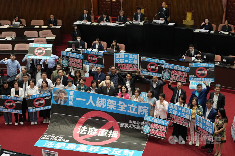 立法院會27日三讀攸關法庭直播的法院組織法部分條文修正草案,院會處理時,民進黨團表達反對之意,並在議場擺出「黃國昌一人綁架全立院;法院非秀場,當事人不是網紅;司法要正義,真相不是靠流量」等標語。中央社記者徐肇昌攝 114年6月27日
