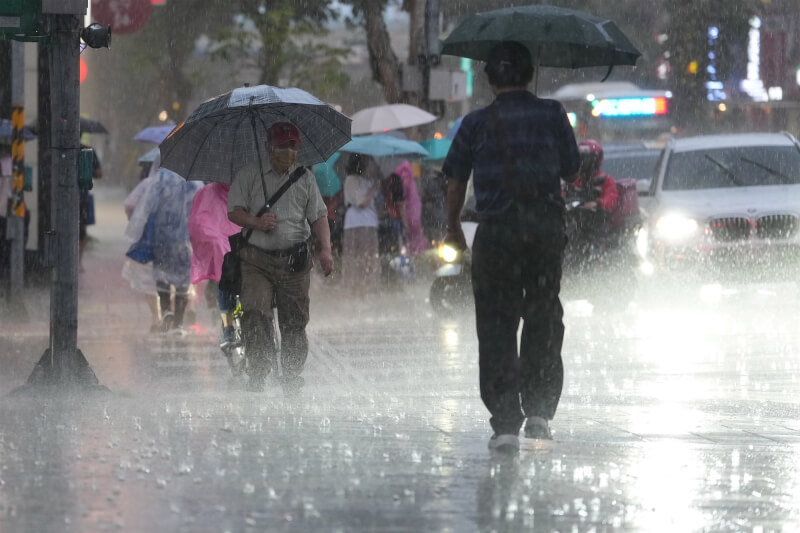 圖為中山區街頭民眾遇雨撐傘。（中央社檔案照片）