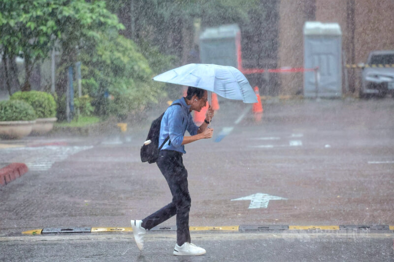 中央氣象署27日下午針對多個縣市發布大雨特報,影響時間恐持續至入夜。台北市中正區午後大雨,雨勢驚人,街頭民眾撐傘快步前行。中央社記者王飛華攝 114年6月27日
