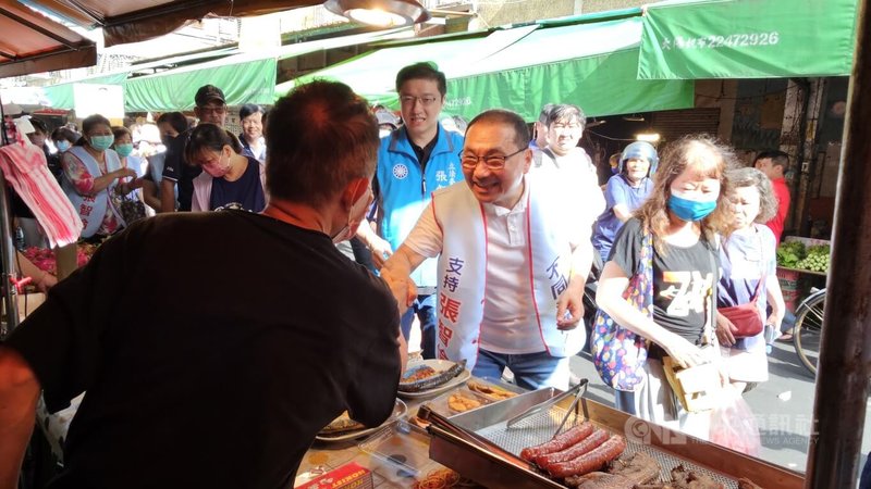 新北市長侯友宜(前右2)29日陪同國民黨立委張智倫(前右3)到傳統市場掃街拜票,與攤商握手致意,呼籲民眾投下不同意罷免票。中央社記者王鴻國攝 114年6月29日