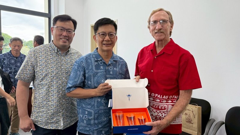 教育部次長張廖萬堅(中)及體育署長鄭世忠(左)受邀赴帛琉參加「第12屆太平洋迷你運動會」,29日與教育顧問詹金斯(Dale Jenkins)交換禮物。(體育署提供)中央社記者黎建忠傳真114年6月29日