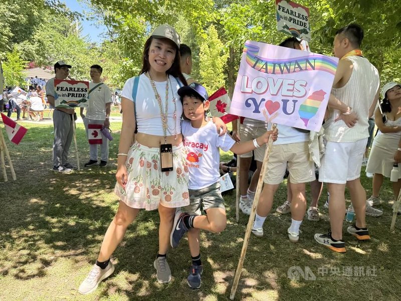 多倫多同志大遊行29日舉行,台灣遊行隊伍格外青春洋溢,還有幾對親子檔。多倫多僑民洪逸青(左)帶著7歲大的兒子首度參加多倫多同志大遊行。中央社記者胡玉立多倫多攝 114年6月30日