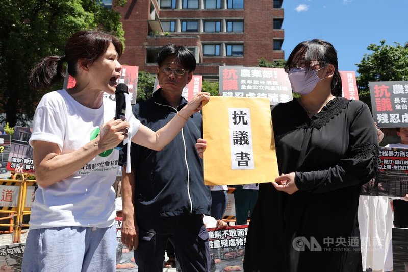 台灣動物社會研究會等多個民團30日上午在農業部前舉行記者會,抗議豬隻活體拍賣制度不當虐待,台灣動物社會研究會副執行長陳玉敏(前左)遞交抗議書,呼籲相關單位提出轉型屠體交易政策。中央社記者趙世勳攝 114年6月30日