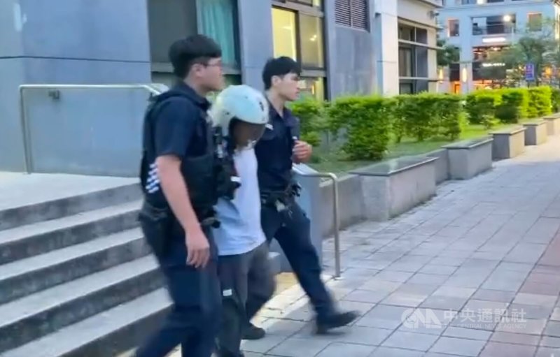 新北市林口區30日上午發生一起命案,某物流公司36歲徐姓女貨車司機(白衣者)疑與同事發生工作糾紛,持刀刺死對方;警方當場將徐女逮捕並帶回,詢後依殺人罪嫌移送新北地方檢察署。(翻攝畫面)中央社記者趙敏雅傳真 114年6月30日