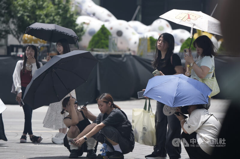 圖為台北市士林區民眾撐傘防曬。(中央社檔案照片)