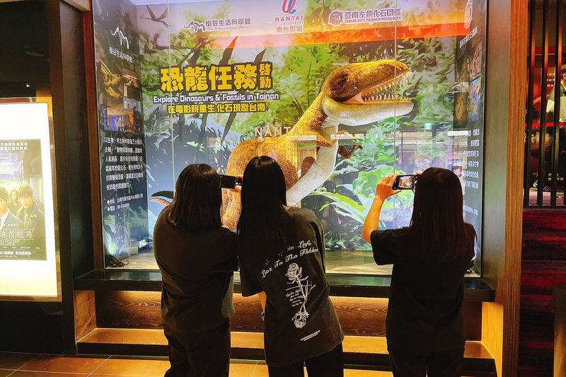 台南樹谷生活科學館與左鎮化石園區暑期推出「恐龍任務」系列活動,左鎮化石園區巨型暴龍玩偶現身南台影城大廳,吸引民眾拍照。(台南市文化局提供)中央社記者楊思瑞台南傳真 114年7月1日