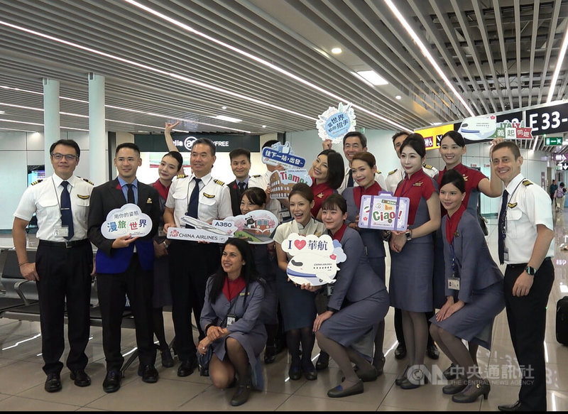 華航「台北-羅馬」航線2日歡慶30週年,華航空服員與機組人員拿著「義起同遊」等小手牌趣味合影,吸引許多候機旅客拍照。中央社記者黃雅詩羅馬攝 114年7月2日