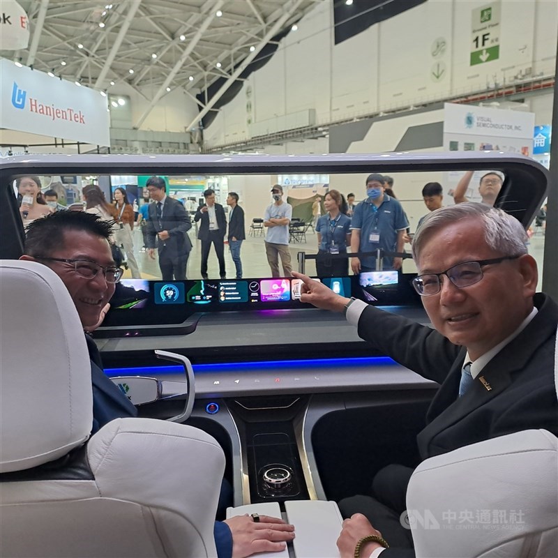 圖為群創董事長洪進揚(左)在Touch Taiwan智慧顯示展展示車用顯示器。 (中央社檔案照片)