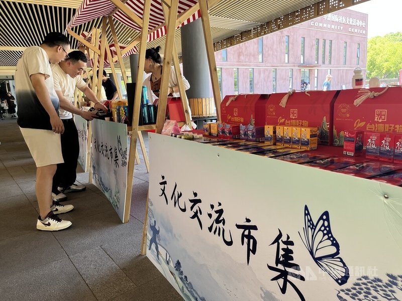 上海市閔行區推動2025年第3屆「上海閔行.台灣月」活動,3日台灣市集陳列台灣特色商品,攤位商家為消費者介紹商品。中央社記者李雅雯上海攝 114年7月3日