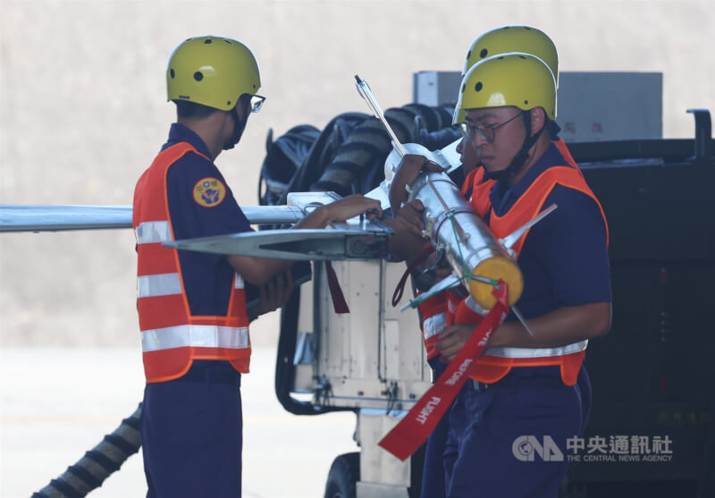 花蓮基地現場執行RF-5E偵察機與F-5F戰機的潛力掛載作業,地勤官兵於接獲命令後,在時限3分鐘內將2枚飛彈掛載於RF-5E偵察機機翼兩端。中央社記者張新偉攝 114年7月3日