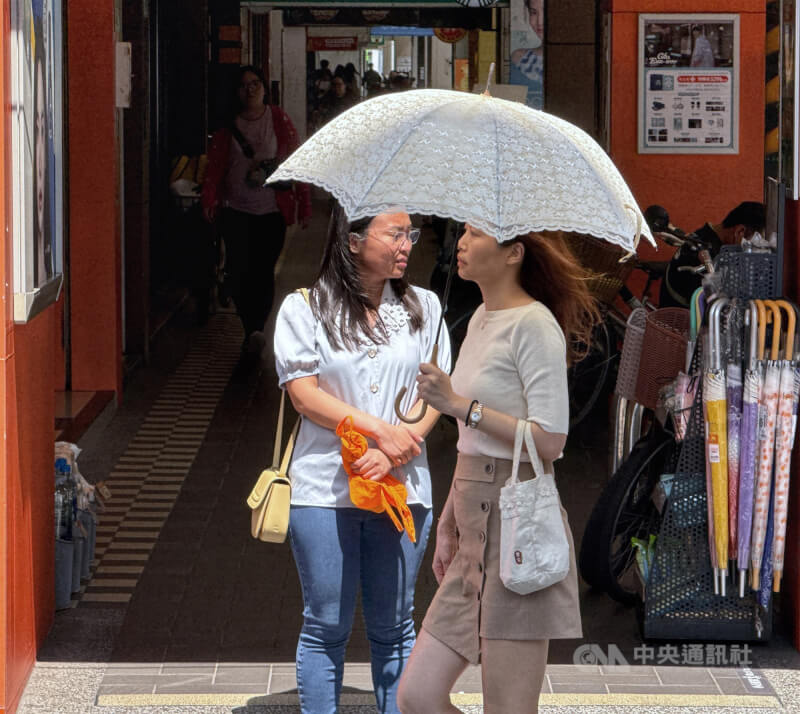 台北內科街頭民眾撐起陽傘走在烈陽下。(中央社檔案照片)