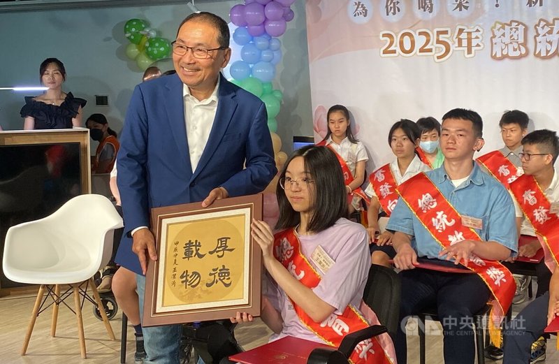 2025總統教育獎國中組得獎者王潔沂(前右)是脊髓性肌肉萎縮症(SMA)患者,樂觀面對病痛與復健,並在書法藝術領域展現卓越才華,她日前將親筆書法「厚德載物」致贈給市長侯友宜(前左)。中央社記者黃旭昇新北市攝 114年7月4日