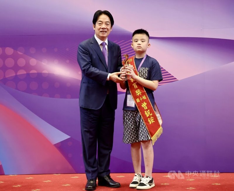 總統賴清德(左)4日下午在總統府出席「2025總統教育獎頒獎典禮」,國小組得獎者曾釩銨(右)開心接受賴總統頒獎表揚。中央社記者張皓安攝 114年7月4日