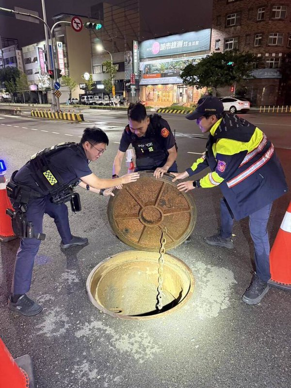 颱風丹娜絲持續逼近,台中市5日傍晚起下起暴雨,造成市區多處路段積淹水,位於西屯區市政路與朝貴路口人孔蓋因水壓一度掀起,員警獲報合力將百公斤重的人孔蓋復位。(民眾提供)中央社記者郝雪卿傳真 114年7月5日