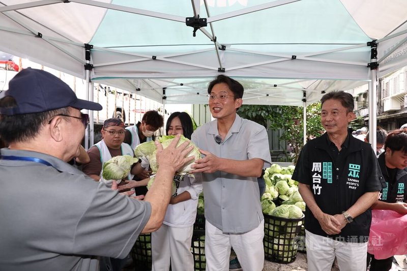 民眾黨主席黃國昌(中,灰衣者)6日上午出席「民眾加菜啦」汐止場活動,現場發送新鮮的高麗菜,為民眾加菜。中央社記者翁睿坤攝 114年7月6日