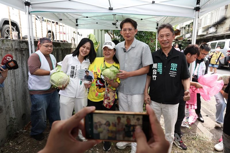 民眾黨主席黃國昌(前右2)6日上午出席「民眾加菜啦」汐止場活動,現場發送新鮮的高麗菜,與民眾合影。中央社記者翁睿坤攝 114年7月6日