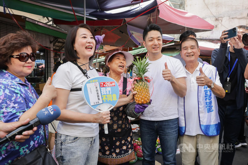 台北市長蔣萬安(左4)6日陪同國民黨立委王鴻薇(左2)到濱江市場掃街宣傳反罷免,呼籲民眾投下「不同意罷免」票,有攤商特別送上象徵好運的鳳梨。中央社記者裴禛攝 114年7月6日